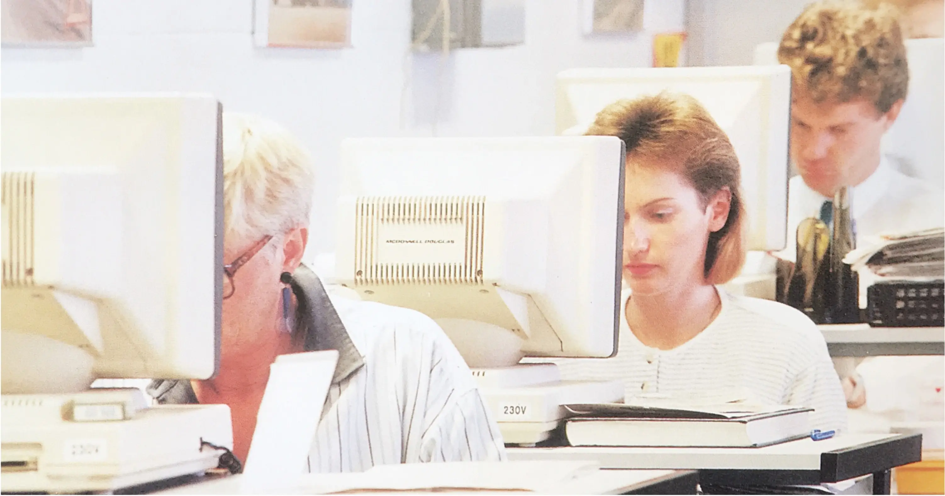 old photo of 3 people on computers