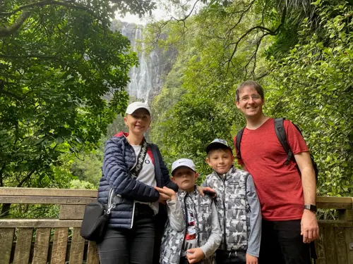family standing infront of waterfall