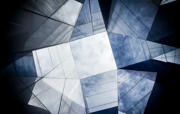 Glass building with cloudy sky loading=